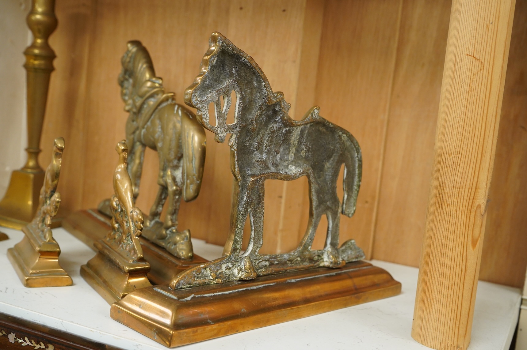 A bronze figure of a horse, two pairs of brass doorstops and a similar pair of candlesticks, 25cm
